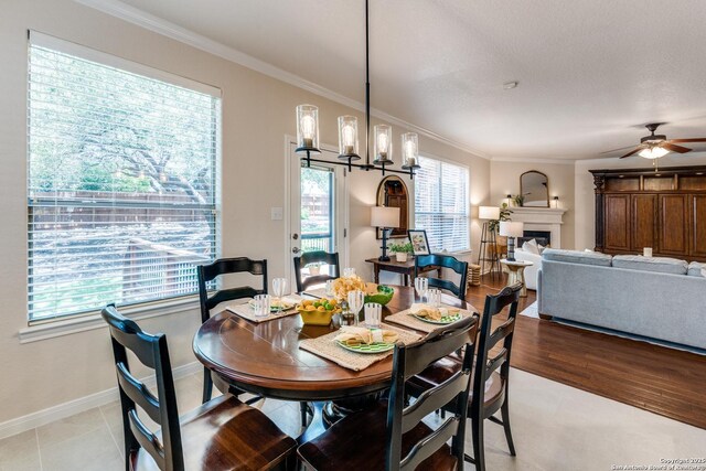 3415 Crest Noche Dr, San Antonio, TX 78261 - dining space with ornamental molding, ceiling fan, a chandelier, and a glass covered fireplace