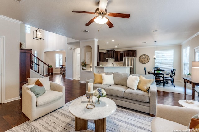 3415 Crest Noche Dr, San Antonio, TX 78261 - living room featuring wood finished floors, a ceiling fan, ornamental molding, arched walkways, and stairs