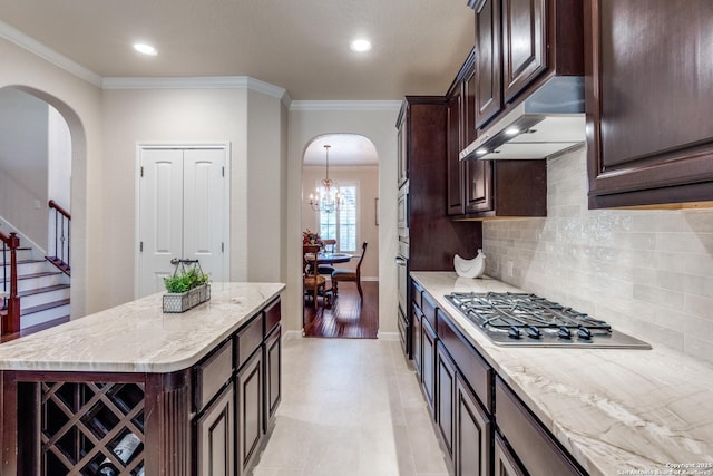 3415 Crest Noche Dr, San Antonio, TX 78261 - kitchen with stainless steel gas cooktop, arched walkways, extractor fan, tasteful backsplash, and dark brown cabinetry