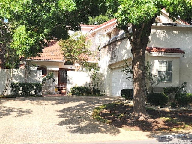 1022 River Gln W, San Antonio, TX 78216 - view of front facade featuring a garage, driveway, a tile roof, and stucco siding