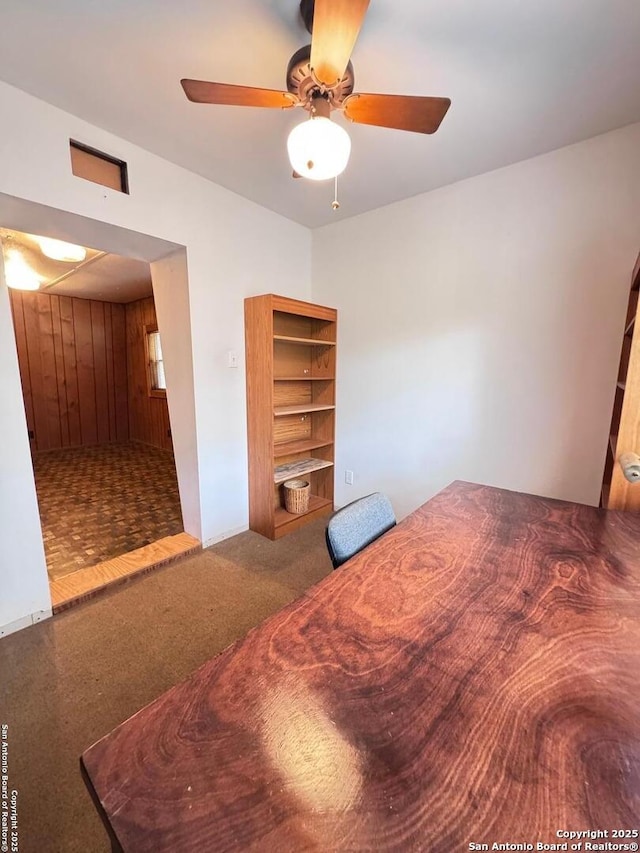 323 N Scenic Loop, Canyon Lake, TX 78133 - bedroom with carpet floors, wood walls, and a ceiling fan