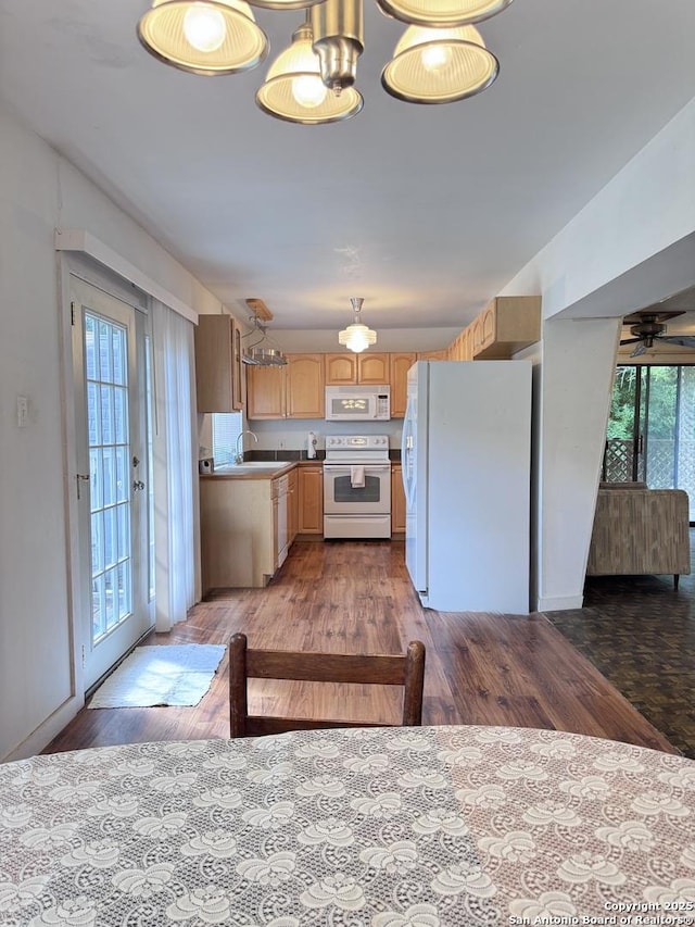323 N Scenic Loop, Canyon Lake, TX 78133 - kitchen featuring white appliances, wood finished floors, light brown cabinets, and a chandelier