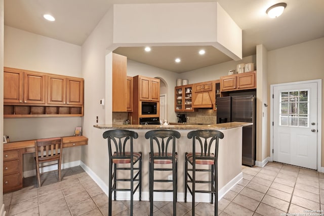 7 Mcinnis, Bulverde, TX 78163 - kitchen with freestanding refrigerator, black microwave, light tile patterned floors, a breakfast bar, and tasteful backsplash