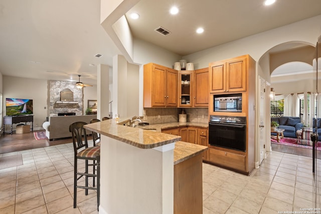 7 Mcinnis, Bulverde, TX 78163 - kitchen featuring black oven, stainless steel microwave, open floor plan, a peninsula, and recessed lighting