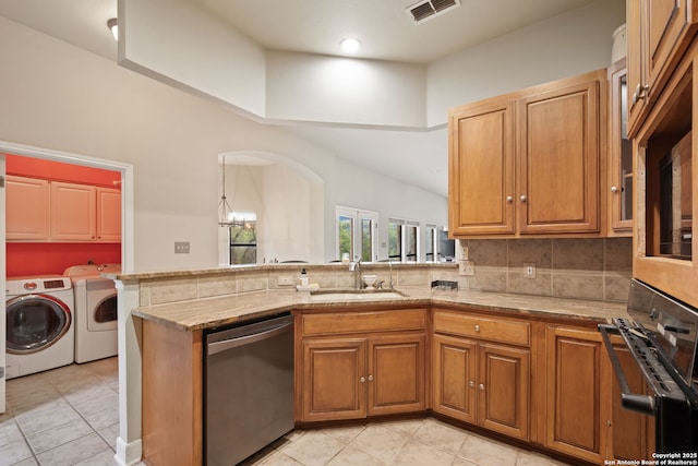 7 Mcinnis, Bulverde, TX 78163 - kitchen with stainless steel dishwasher, washing machine and dryer, black oven, and light stone countertops