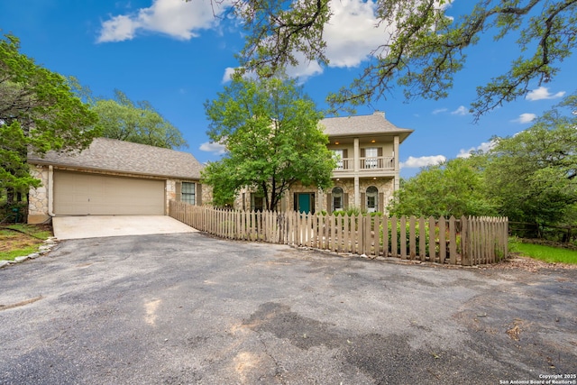 7 Mcinnis, Bulverde, TX 78163 - view of front of home with asphalt driveway, a fenced front yard, a garage, and a balcony