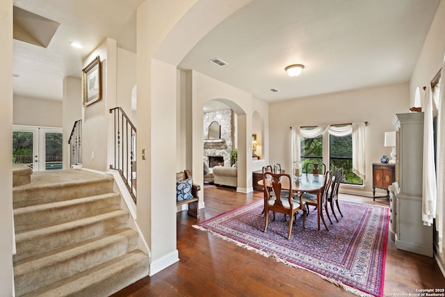7 Mcinnis, Bulverde, TX 78163 - dining area featuring arched walkways, a stone fireplace, stairs, hardwood / wood-style floors, and french doors