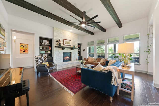 8903 Gate Pass, Boerne, TX 78015 - living room featuring beamed ceiling, ceiling fan, a stone fireplace, and dark wood-style floors