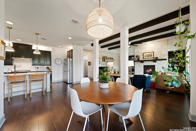 8903 Gate Pass, Boerne, TX 78015 - dining space featuring a fireplace, beamed ceiling, dark wood finished floors, and recessed lighting