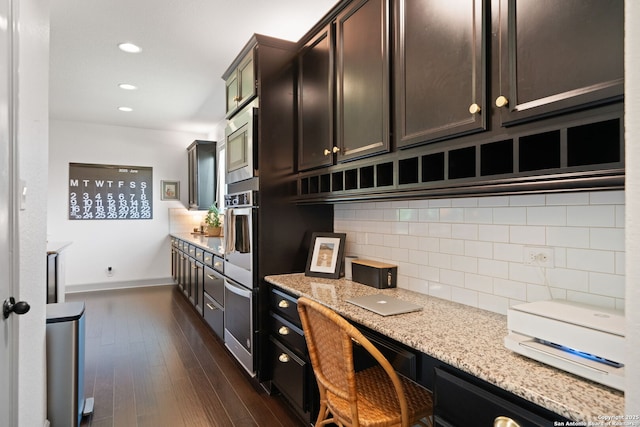 8903 Gate Pass, Boerne, TX 78015 - kitchen with decorative backsplash, dark wood-style floors, recessed lighting, light stone countertops, and stainless steel microwave