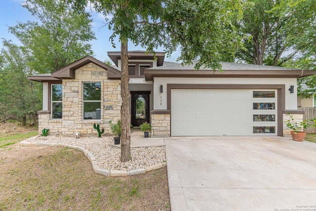 114 Mokukua Ln, Bastrop, TX 78602 - prairie-style home featuring stone siding, an attached garage, concrete driveway, and stucco siding