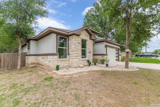 114 Mokukua Ln, Bastrop, TX 78602 - view of front of home featuring stone siding, stucco siding, driveway, and an attached garage