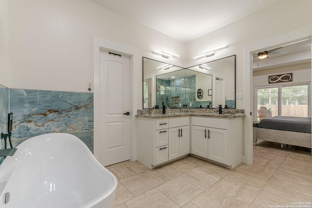 114 Mokukua Ln, Bastrop, TX 78602 - ensuite bathroom featuring double vanity, a freestanding tub, a stall shower, and a ceiling fan