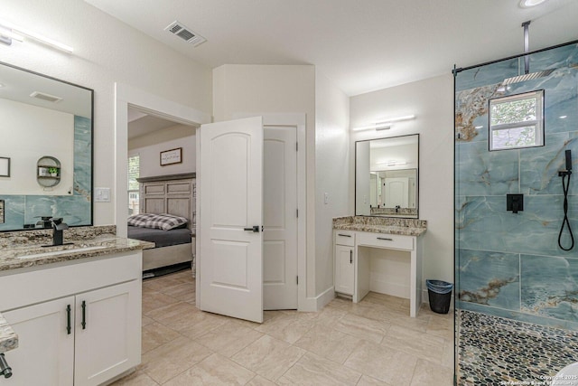 114 Mokukua Ln, Bastrop, TX 78602 - full bathroom featuring a marble finish shower, healthy amount of natural light, and two vanities