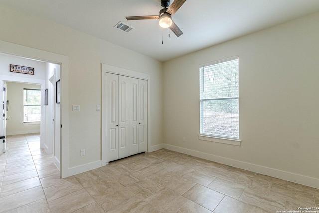 114 Mokukua Ln, Bastrop, TX 78602 - unfurnished bedroom with a closet, ceiling fan, and light tile patterned floors