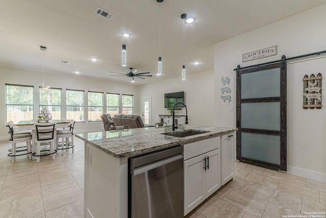 114 Mokukua Ln, Bastrop, TX 78602 - kitchen featuring dishwasher, a barn door, a ceiling fan, white cabinets, and an island with sink