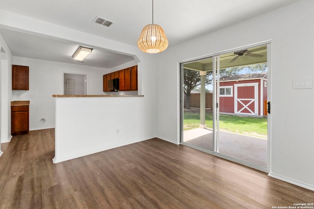 221 Passerina Spur, Schertz, TX 78154 - unfurnished dining area featuring dark wood-type flooring and ceiling fan