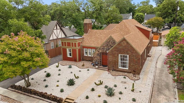 138 E Lullwood Ave, San Antonio, TX 78212 - tudor home featuring a chimney, brick siding, and roof with shingles