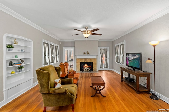 138 E Lullwood Ave, San Antonio, TX 78212 - living area featuring ceiling fan, wood finished floors, a brick fireplace, and crown molding