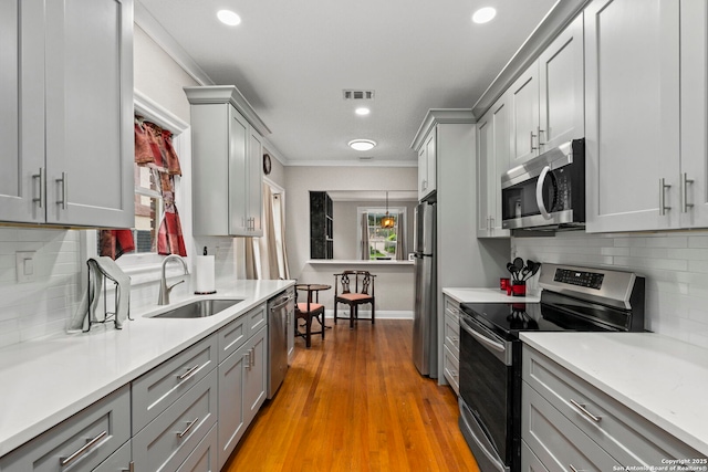 138 E Lullwood Ave, San Antonio, TX 78212 - kitchen featuring stainless steel appliances, gray cabinets, crown molding, light countertops, and tasteful backsplash