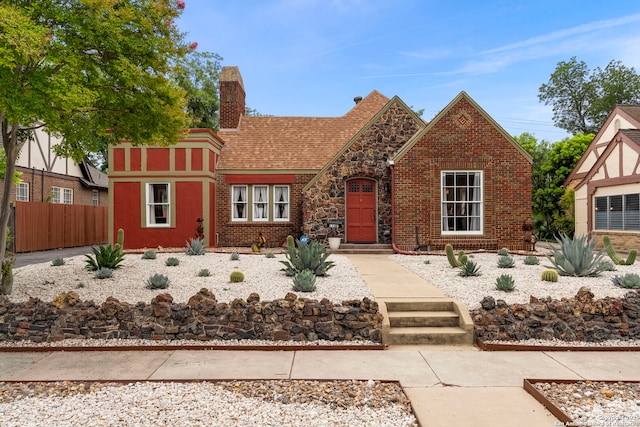 138 E Lullwood Ave, San Antonio, TX 78212 - tudor-style house featuring a chimney, brick siding, and stone siding
