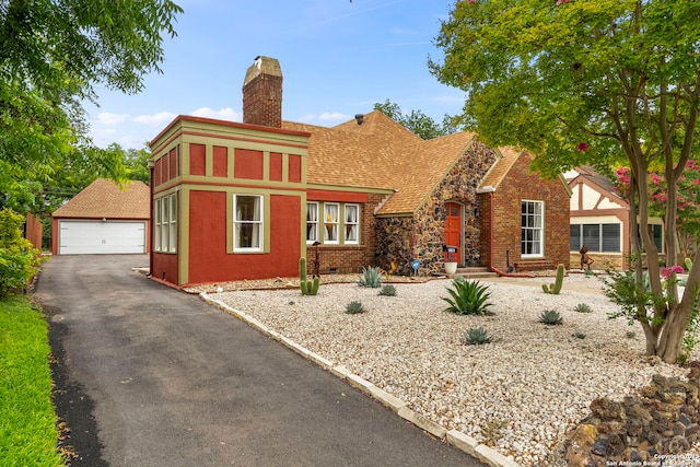 138 E Lullwood Ave, San Antonio, TX 78212 - tudor home with a chimney, a detached garage, an outbuilding, roof with shingles, and brick siding