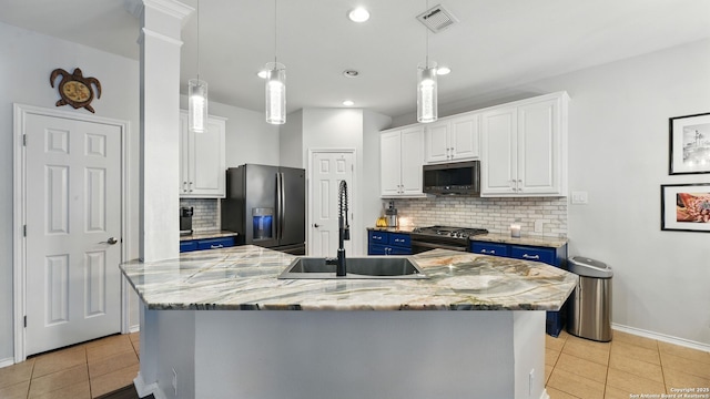1739 Oak Gln, New Braunfels, TX 78132 - kitchen featuring stainless steel appliances, blue cabinetry, white cabinets, light tile patterned floors, and tasteful backsplash