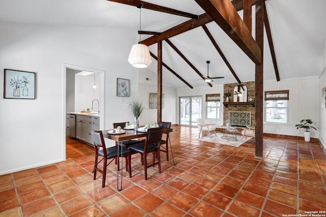 2116 Turkey Ledge, San Antonio, TX 78232 - tiled dining area with beamed ceiling, high vaulted ceiling, a ceiling fan, and a fireplace