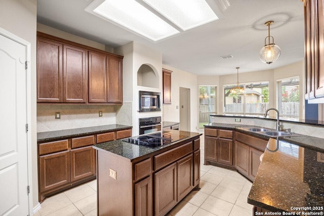 24831 Cloudy Crk, San Antonio, TX 78255 - kitchen with black appliances, light tile patterned floors, pendant lighting, and dark stone counters