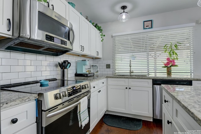 8211 Littleport, San Antonio, TX 78239 - kitchen featuring appliances with stainless steel finishes, white cabinets, backsplash, dark wood-type flooring, and light stone countertops