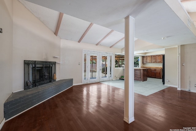 6914 Glen Gate, San Antonio, TX 78239 - unfurnished living room featuring light wood-style floors, a brick fireplace, and french doors