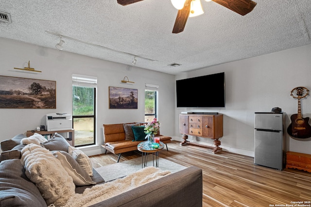 30650 Wildcat Dr, Bulverde, TX 78163 - living area featuring rail lighting, a ceiling fan, a textured ceiling, and light wood-type flooring
