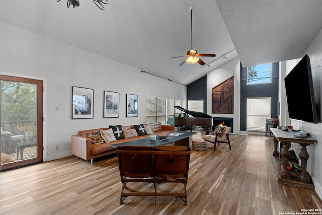 30650 Wildcat Dr, Bulverde, TX 78163 - living room featuring light wood finished floors, high vaulted ceiling, a ceiling fan, and a fireplace
