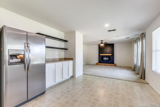 11747 Silver Pr, San Antonio, TX 78254 - kitchen with stainless steel fridge, a ceiling fan, white cabinetry, open shelves, and light carpet