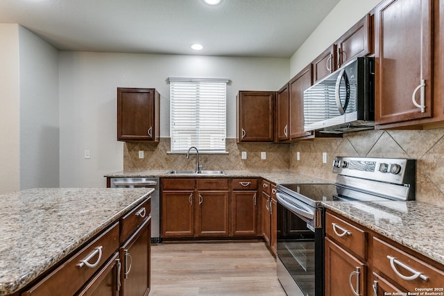 27338 Wrought Iron, San Antonio, TX 78260 - kitchen with appliances with stainless steel finishes, light wood-type flooring, light stone counters, recessed lighting, and tasteful backsplash
