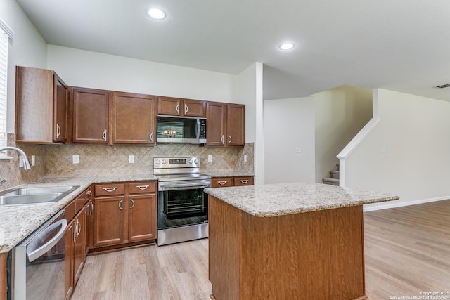 27338 Wrought Iron, San Antonio, TX 78260 - kitchen featuring stainless steel appliances, light wood-style floors, a center island, decorative backsplash, and light stone counters