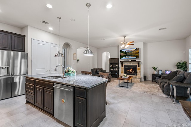 130 Boulder Crk, Boerne, TX 78006 - kitchen featuring stainless steel appliances, arched walkways, light stone countertops, open floor plan, and a ceiling fan