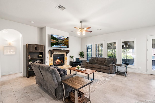 130 Boulder Crk, Boerne, TX 78006 - living area with arched walkways, a fireplace, a ceiling fan, and light tile patterned floors
