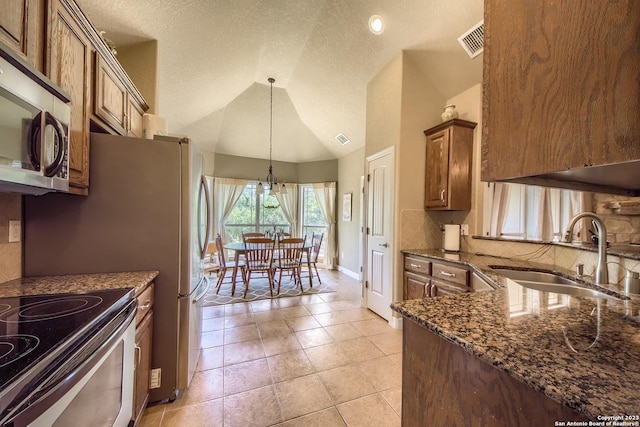 1463 Birch Ln, Fischer, TX 78623 - kitchen with appliances with stainless steel finishes, tasteful backsplash, dark stone countertops, vaulted ceiling, and hanging light fixtures