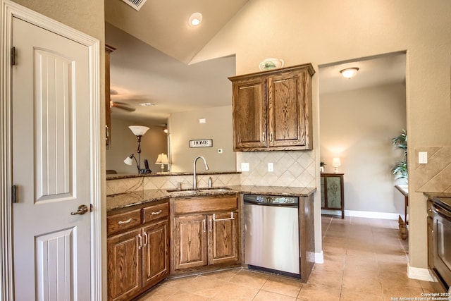1463 Birch Ln, Fischer, TX 78623 - kitchen with stainless steel dishwasher, decorative backsplash, dark stone countertops, light tile patterned floors, and lofted ceiling