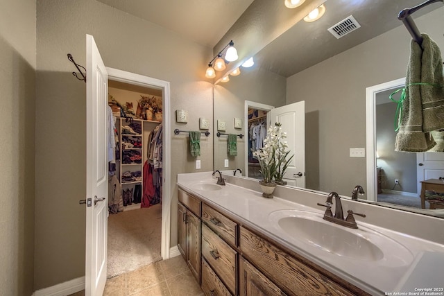 1463 Birch Ln, Fischer, TX 78623 - bathroom featuring double vanity, a walk in closet, and tile patterned floors