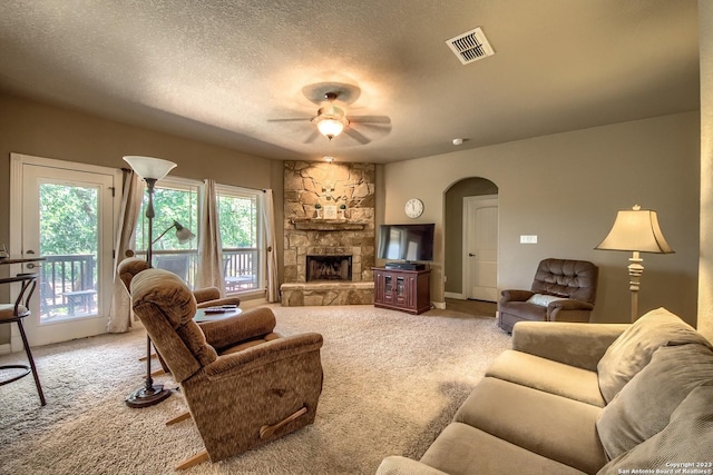 1463 Birch Ln, Fischer, TX 78623 - carpeted living room with arched walkways, ceiling fan, a textured ceiling, and a fireplace
