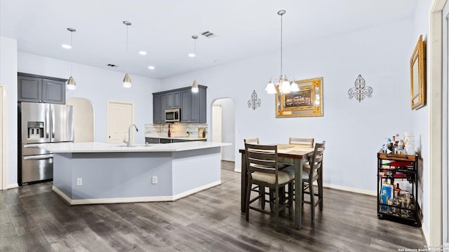 1238 Sugar Land, New Braunfels, TX 78130 - kitchen with stainless steel appliances, arched walkways, light countertops, dark wood-style floors, and recessed lighting