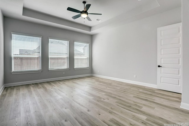 223 Azalea Aly, Castroville, TX 78009 - spare room featuring a tray ceiling, light wood finished floors, and a ceiling fan