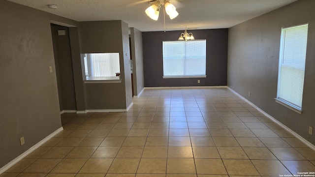 8310 Border Rdg, San Antonio, TX 78240 - spare room with healthy amount of natural light, a smoke detector, a ceiling fan, a chandelier, and a textured ceiling