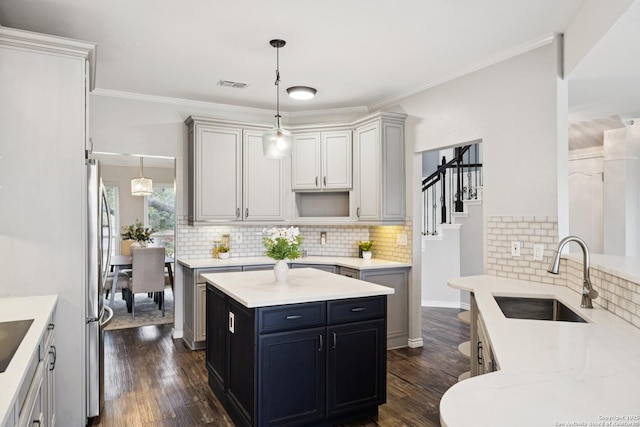 4130 Luckenbach, San Antonio, TX 78251 - kitchen featuring tasteful backsplash, dark wood-style floors, decorative light fixtures, crown molding, and freestanding refrigerator