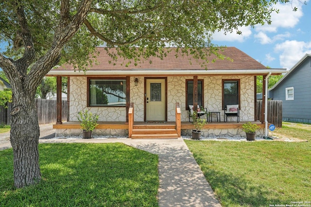 714 N Esplanade, Karnes City, TX 78118 - bungalow featuring a porch, stone siding, and roof with shingles