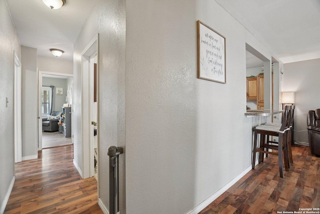 714 N Esplanade, Karnes City, TX 78118 - corridor featuring dark wood-style floors and a textured wall