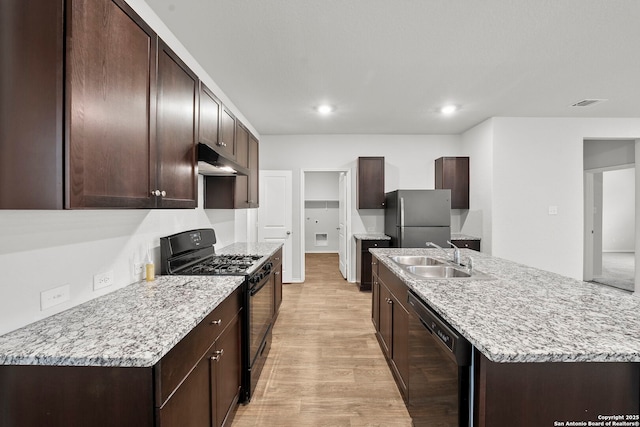 14034 Breccia, San Antonio, TX 78253 - kitchen featuring black appliances, under cabinet range hood, light wood finished floors, dark brown cabinets, and recessed lighting