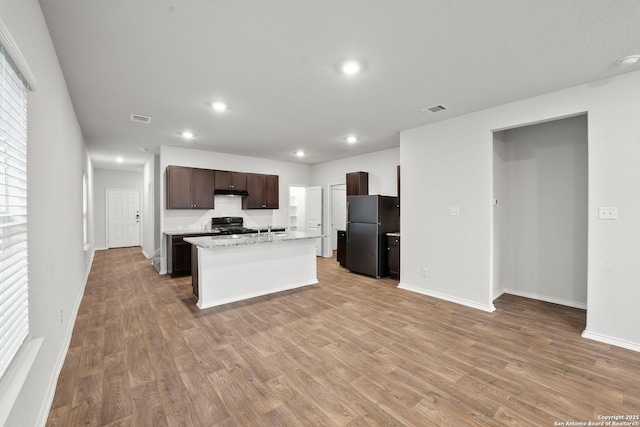 14034 Breccia, San Antonio, TX 78253 - kitchen with freestanding refrigerator, light wood-type flooring, dark brown cabinetry, recessed lighting, and under cabinet range hood